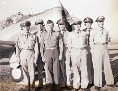 Flight instructors posing in front of a training aircraft, Hancock College of Aeronautics